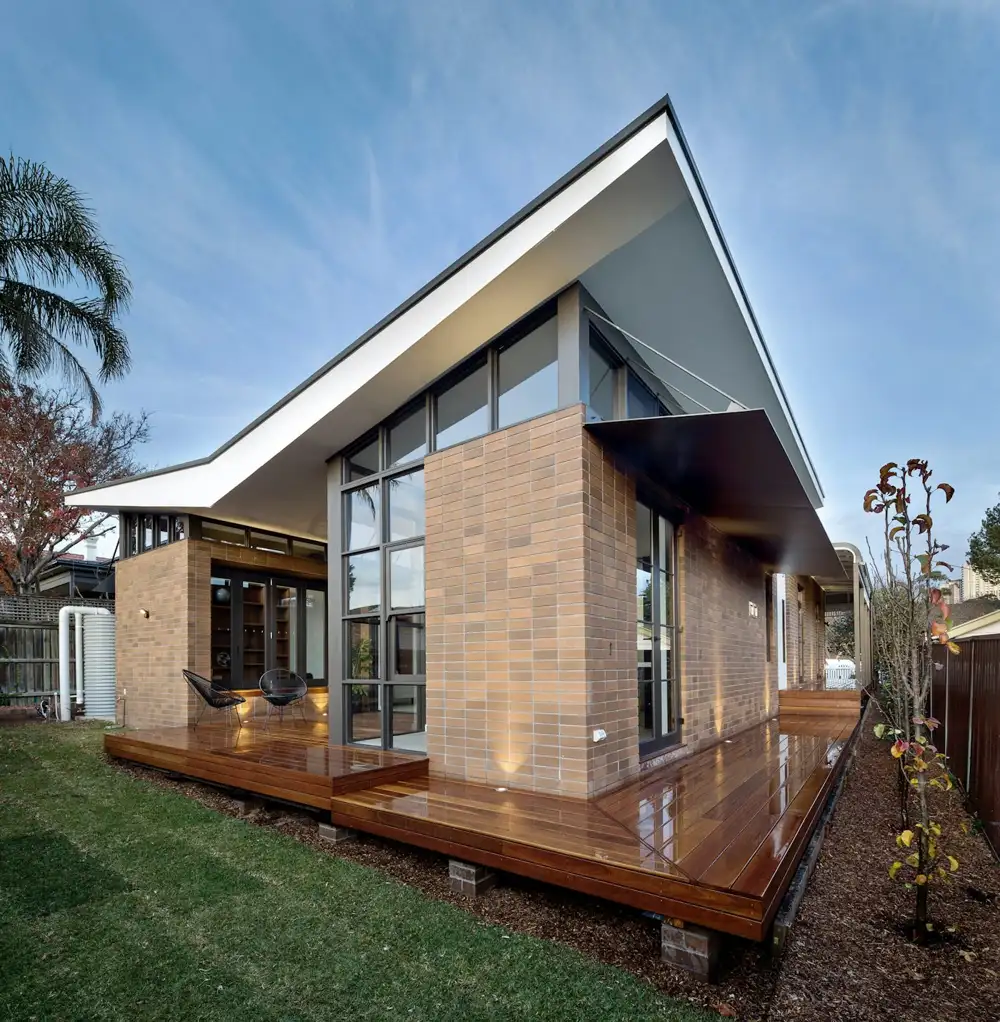 Contemporary single-storey brick and glass house with a timber deck