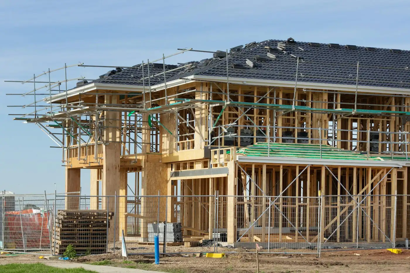 Two-storey timber-framed house under construction with scaffolding